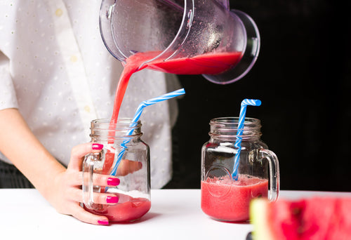 Pouring fresh juice from a professional blender.